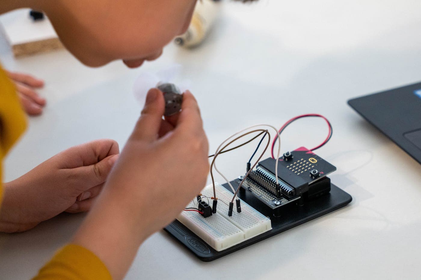 A child learning electronics with wires and components