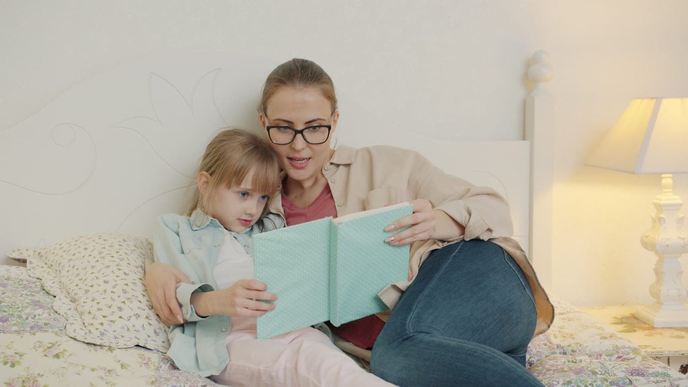 A parent and child reading together at home