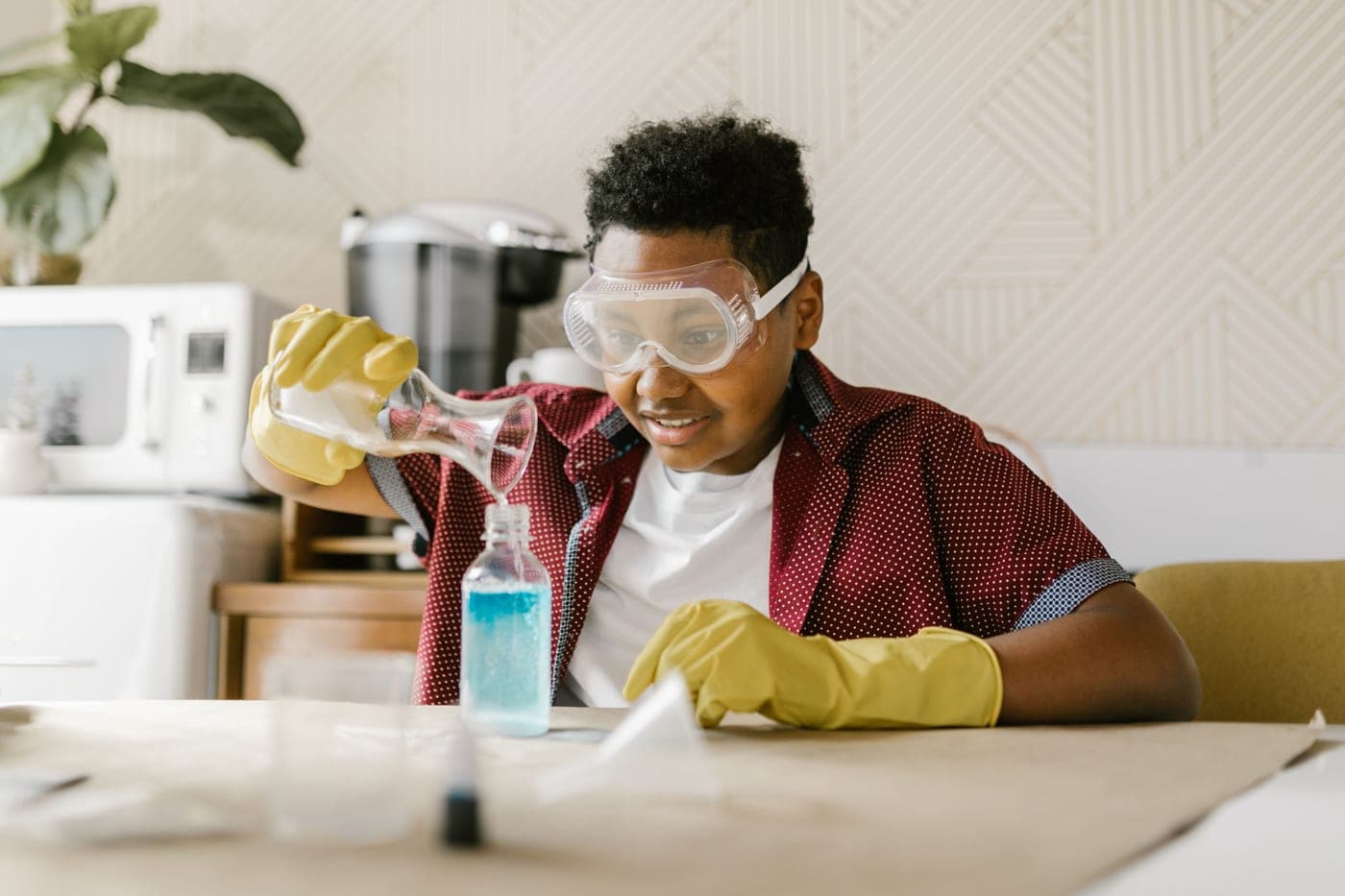 A child running a science experiment at a kitchen table